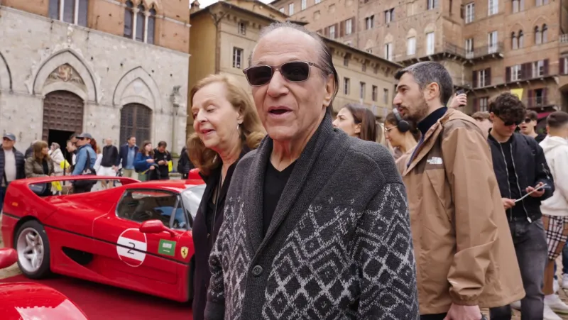 Joe Cerisano in Siena beside a Ferrari