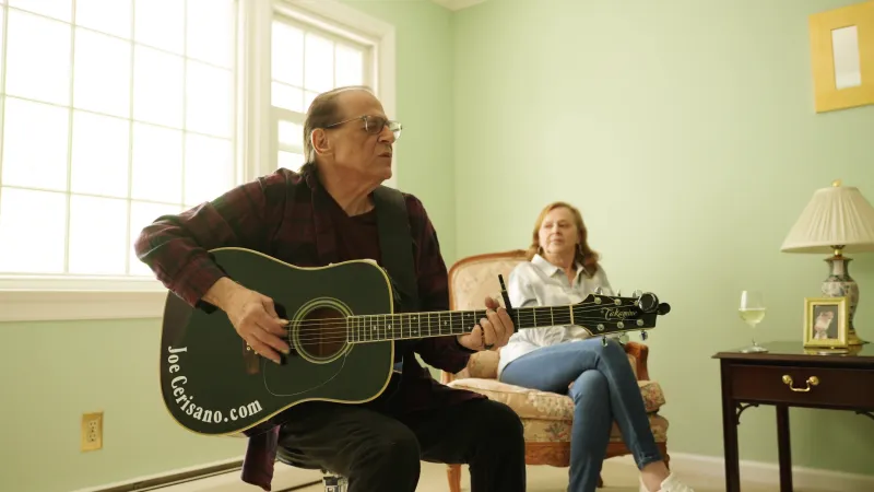 Joe playing guitar in his living room