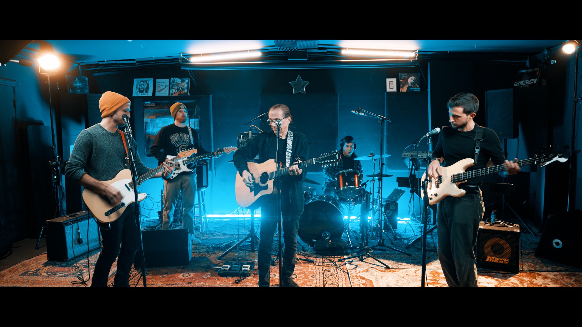 Full band performing in blue-lit studio